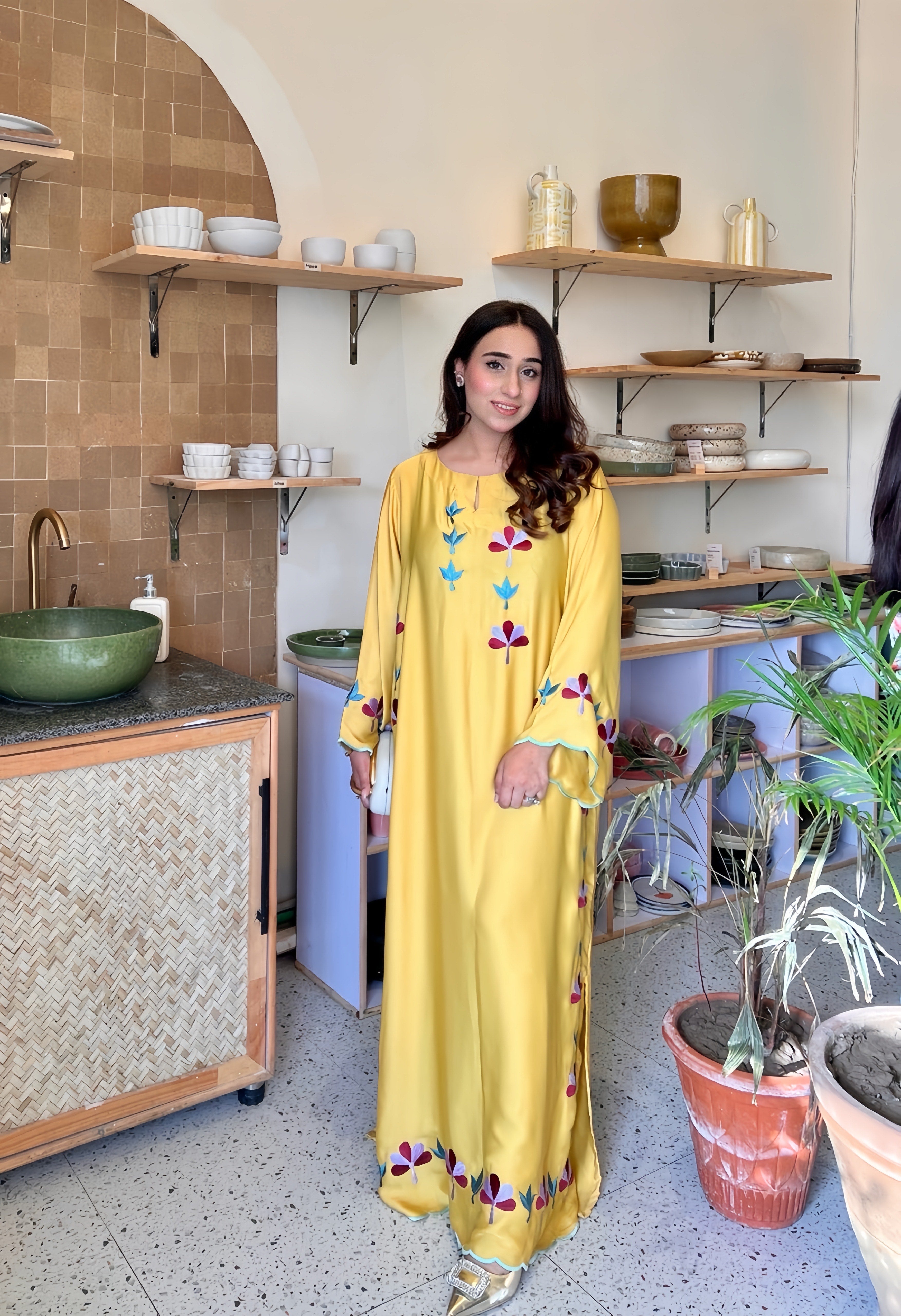 Woman in a yellow dress with floral patterns.
